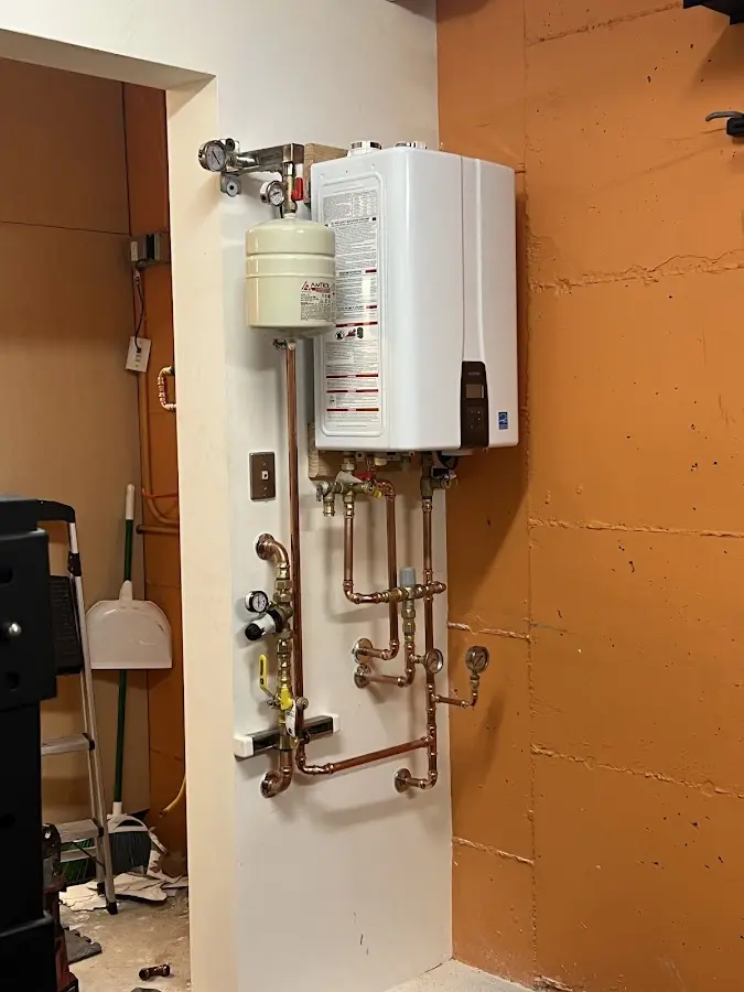 Plumbing technician inspecting water heater connections in Northdale